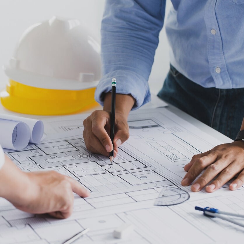 engineer meeting for an architectural project. working with partner and engineering tools working on blueprint architectural project at the construction site at desk in the office.