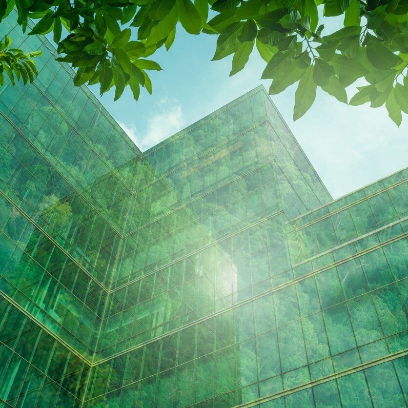 Eco-friendly building in the modern city. Sustainable glass office building with tree for reducing heat and carbon dioxide. Office building with green environment. Corporate building reduce CO2.